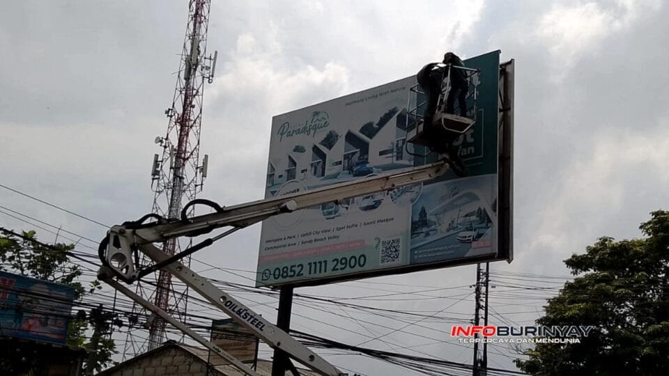 Petugas Satgas Pemkab Bandung menurunkan papan reklame tanpa izin menggunakan crane di kawasan Soreang saat operasi penertiban reklame ilegal.