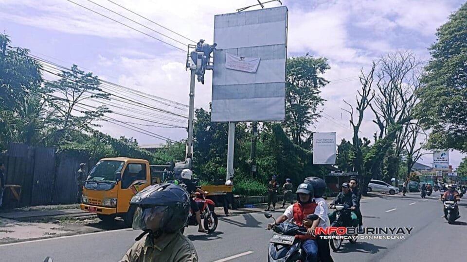 Petugas Satgas Pemkab Bandung memasang segel pada papan reklame ilegal di Jalan Terusan Kopo Sayati, Margahayu, Kabupaten Bandung, Kamis (23/10/2025)
