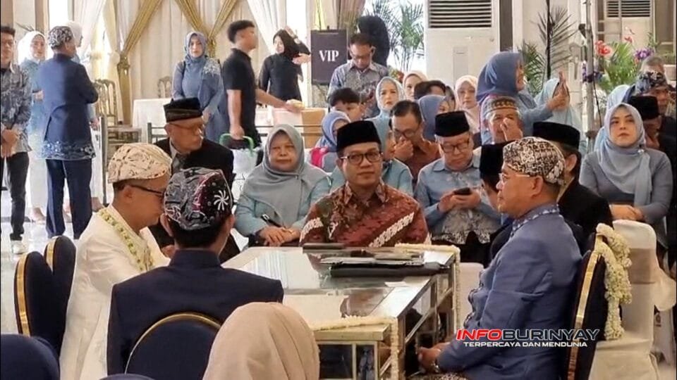 Bupati Bandung Dr. HM. Dadang Supriatna mengenakan peci hitam dan batik coklat duduk sebagai saksi akad nikah Suci Nedia Putri dan Nizar Jati Fadhilah di Sarajiwa Ballroom, Soreang.