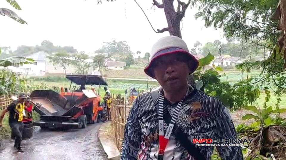 Kepala Desa Ciwidey sedang meninjau pengerjaan jalan hotmix di RW 27–28 bersama tim lapangan.