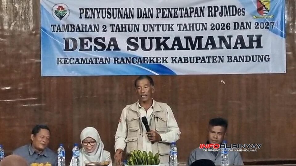 Kepala Desa Sukamanah, H. Dede Rahim, menyampaikan sambutan pada Musyawarah Desa penyusunan dan penetapan RPJMDes tambahan 2026–2027 di GOR Desa Sukamanah, Kecamatan Rancaekek, Kabupaten Bandung