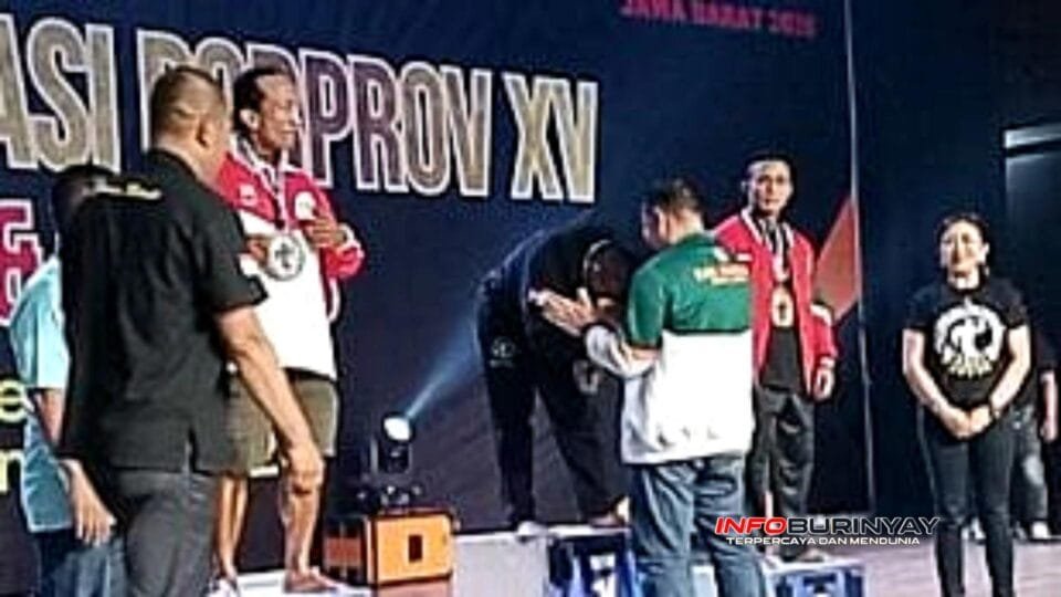 Ketua KONI kabupaten Bandung H.Yana Suryana S.Pd.I mengalungi medali emas kepada Andri Serat atlet kabupaten Bandung peraih juara 1, binaraga, di Art Centre, Garut, Minggu, (23/11/25).