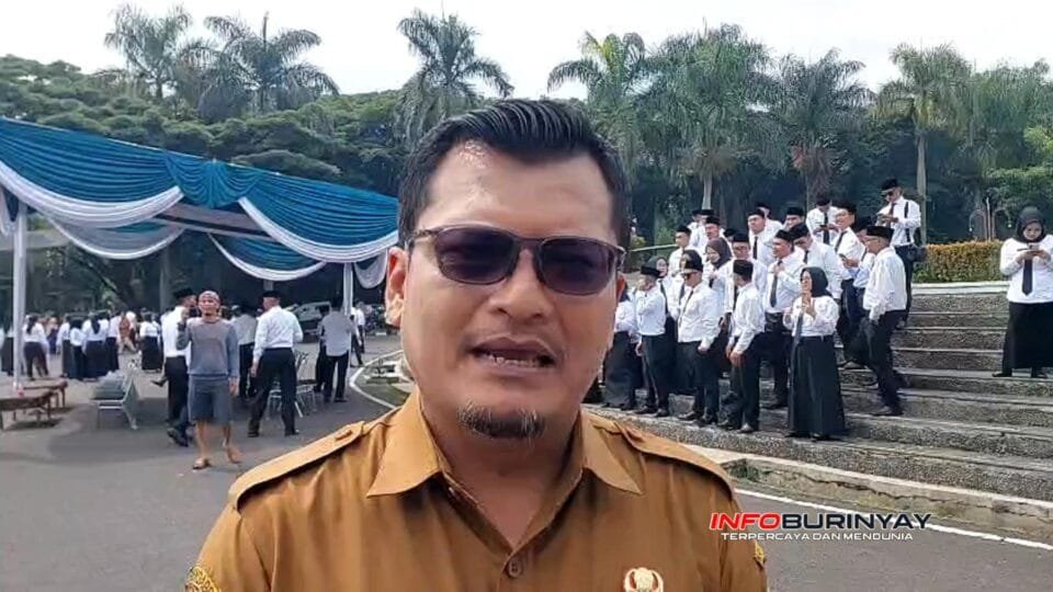 Pejabat Dinas Kominfo Kabupaten Bandung sedang memberikan wawancara di area pelantikan P3KPW dengan latar peserta berseragam putih dan hitam.