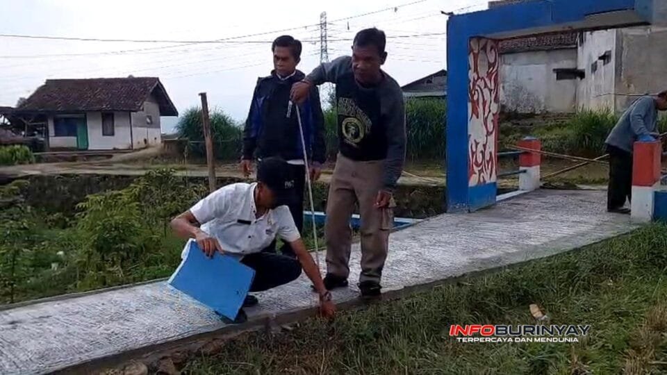 Petugas Monev Kecamatan Ciwidey memeriksa ketebalan dan kondisi rabat beton jalan lingkungan di Desa Sukawening sebagai bagian evaluasi BKK dan Banprov 2025.
