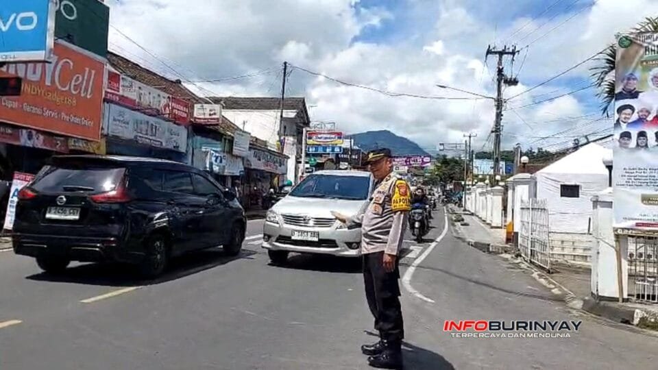Petugas Polsek Pasirjambu Polresta Bandung mengatur arus lalu lintas di Jalan Bhayangkara, Alun-Alun Ciwidey, saat pengamanan Nataru 2025.