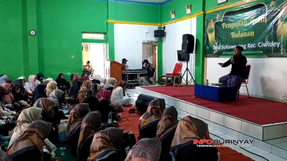 Suasana pengajian rutin bulanan Desa Sukawening di aula desa, dengan jemaah perempuan memenuhi ruangan dan penceramah menyampaikan tausiah