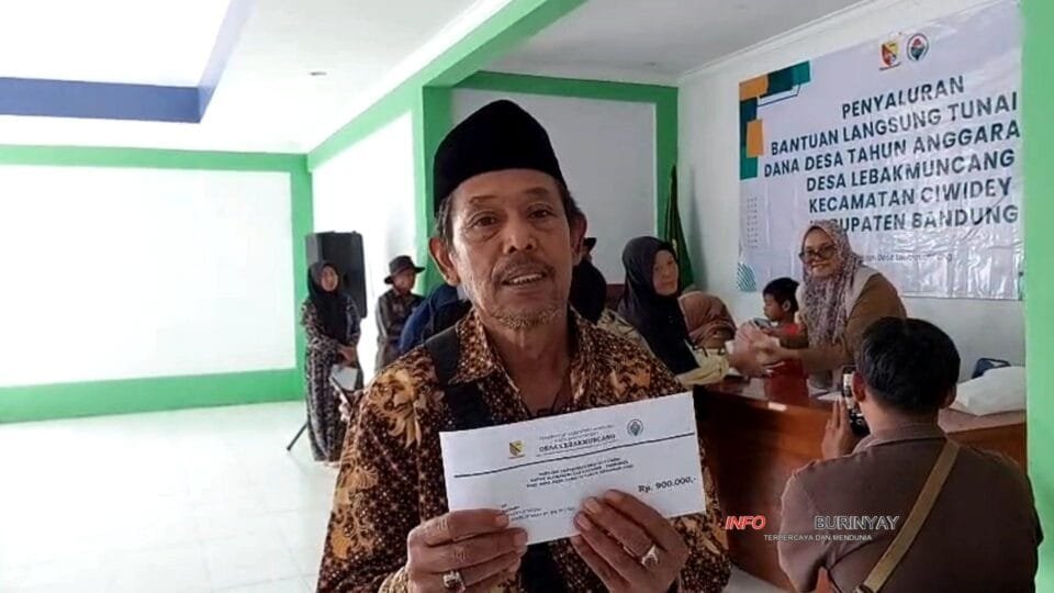 Warga penerima BLT Desa Lebakmuncang menunjukkan amplop bantuan Rp900 ribu saat penyaluran BLT Dana Desa di Aula Desa Lebakmuncang, Kecamatan Ciwidey.