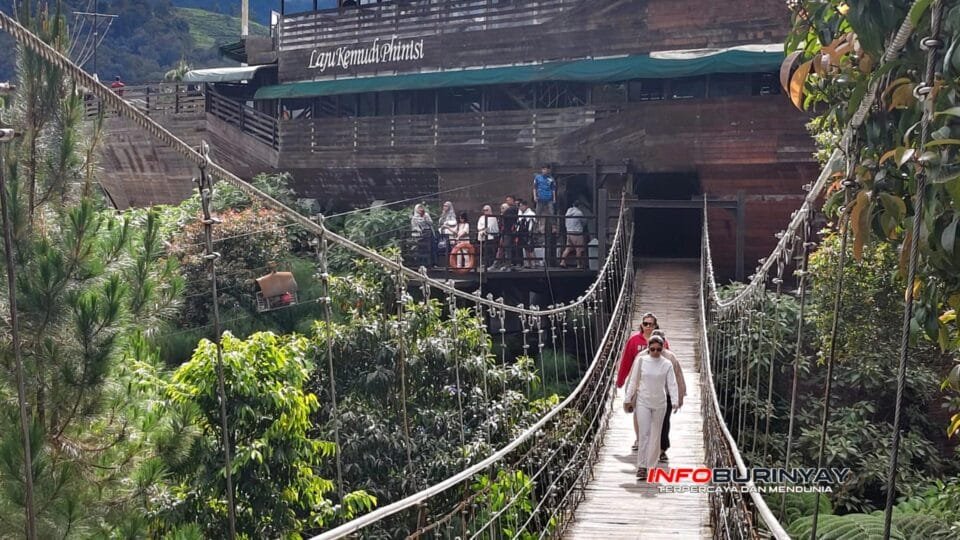 Wisatawan melintasi jembatan ikonik sepanjang 370 meter di kawasan Glamping Lakeside Situ Patenggang, Ciwidey, Kabupaten Bandung, menjelang libur Natal dan Tahun Baru 2026.