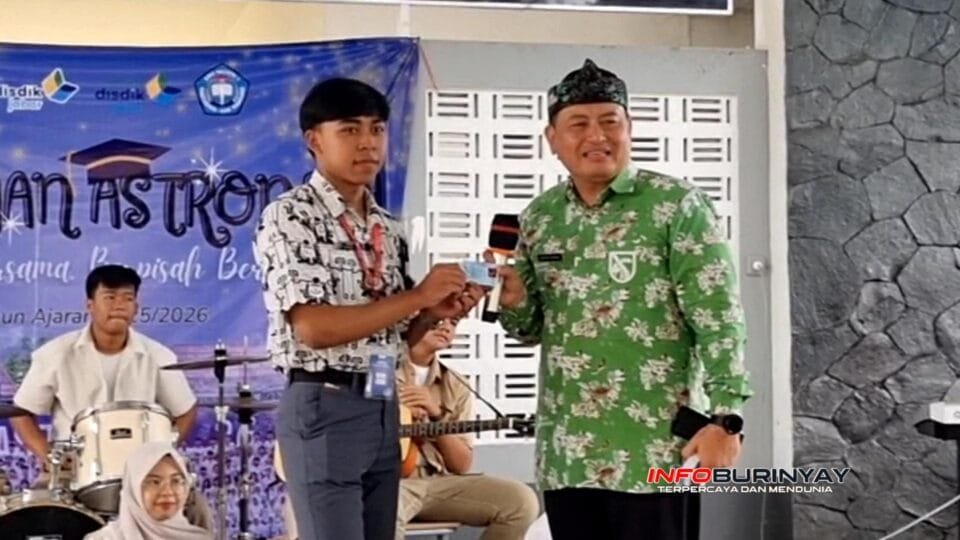 Camat Rancaekek H. Gugum Gumilar menyerahkan e-KTP pemula kepada siswa SMAN 1 Rancaekek dalam acara Perpisahan Astronova 2026 di Dome SMAN 1 Rancaekek, Kabupaten Bandung.
