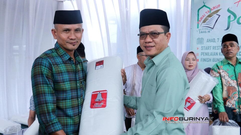 Bupati Bandung Dadang Supriatna menyerahkan kain kafan kepada perwakilan masyarakat dalam tradisi berbagi kain kafan menjelang Tahun Baru Islam 1 Muharam di Kabupaten Bandung.